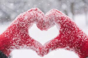 snowy mittens forming the shape of a heart