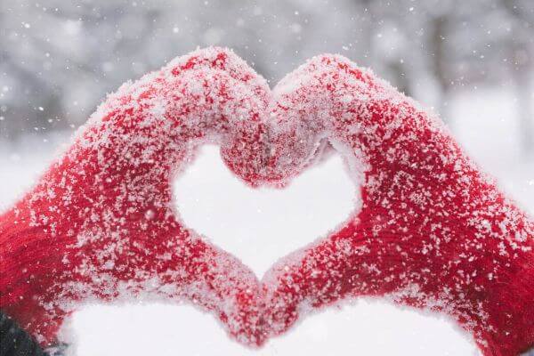 snowy mittens forming the shape of a heart