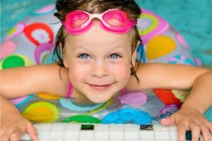 child looking up from inside a swimming pool