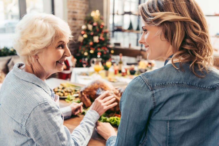 women smiling next to a meal prepared for the holidays