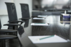 table with pens and papers in a conference room